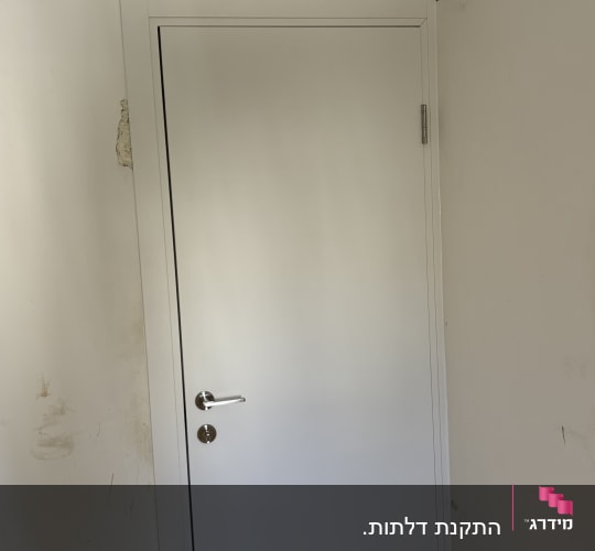 דלת לבנה מותקנת בקיר פנימי